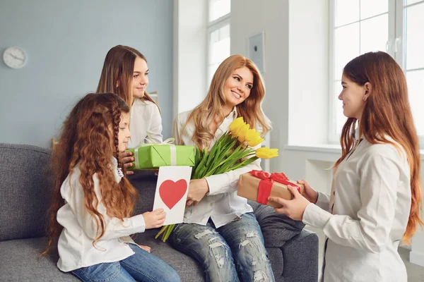 행복 한 엄마들. 딸들은 집에서 어머니에게 꽃다발을 준다. — 스톡 사진
