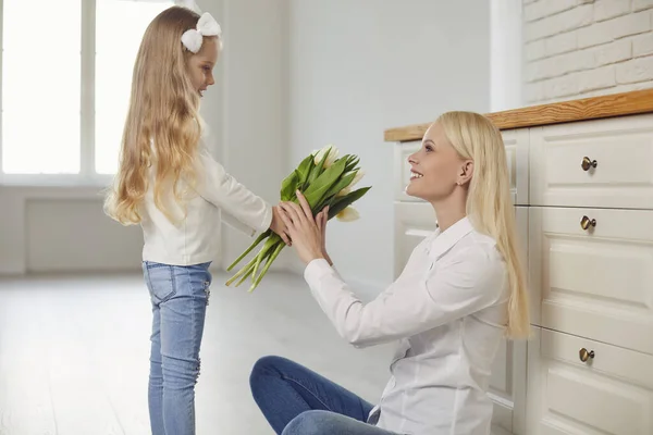 Boldog anyák napját. A lánya tulipánokat ad az anyjának otthon.. — Stock Fotó