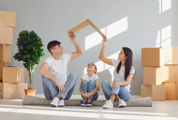 Glückliche Familie mit Kindern zieht in ein neues Wohnhaus. Mutter Vater und kleine Tochter in ein neues Haus. — Stockfoto