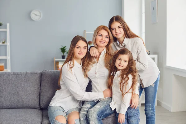 행복 한 엄마들. 방에 있는 소파에 앉아 있는 한 어머니와 세 딸. — 스톡 사진