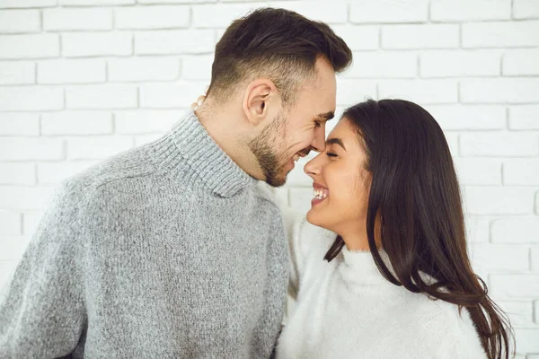 Jovem casal sorrindo sorrindo em um fundo de tijolo branco — Fotografia de Stock
