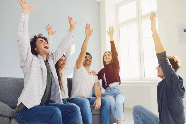 Happy people cheerfully connected their hands in a room with a window. — Stock Photo, Image