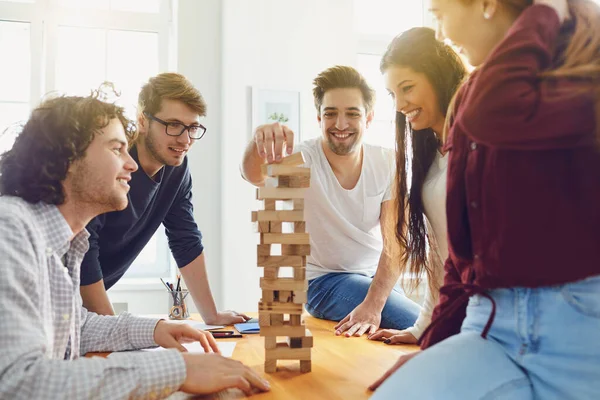 Jongeren hebben plezier met bordspelen aan een tafel in de kamer. — Stockfoto