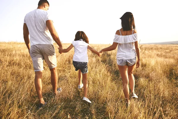 Wandelen paar met kind in het veld — Stockfoto