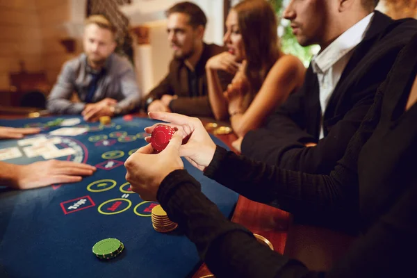 Fichas em uma mão de jogador de jogo em uma mesa em um cassino . — Fotografia de Stock