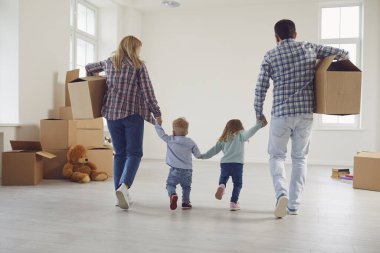 Mutlu ve çocuklu bir aile yeni bir apartmanda kutularla taşınıyor..