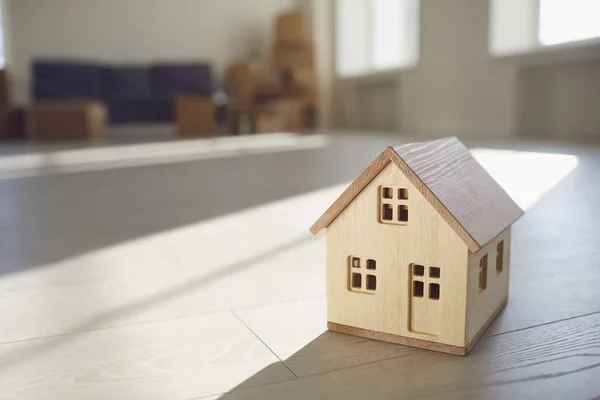 Model drewnianego domu na podłodze w nowym jasnym słonecznym domu. — Zdjęcie stockowe