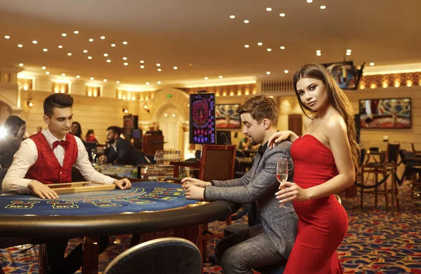 Νεαρό ζευγάρι που παίζει κάρτες πόκερ ρουλέτα σε ένα καζίνο. — Φωτογραφία Αρχείου