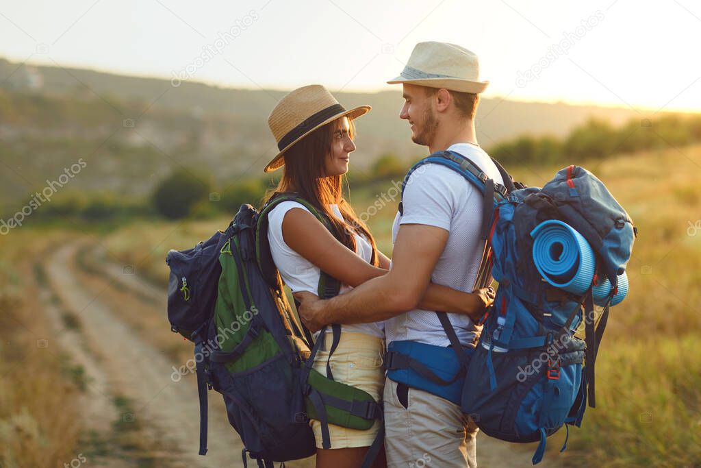 Couple hikers with backpack walking on hike in nature