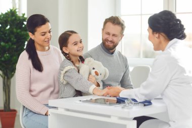 Çocuk kızın ailesi klinikteki doktoru ziyaret ediyor..