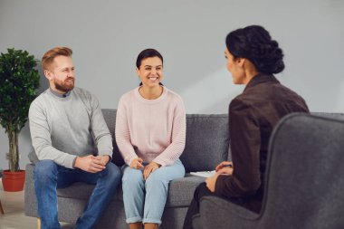 Aile psikoloğu. Ofiste ailesiyle psikoterapi seansında olan bir kadın psikolog..