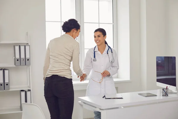 Médica pediatra ginecologista falando cliente sentado em uma mesa em um escritório da clínica . — Fotografia de Stock