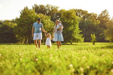 Gün batımında parkta çocuklu mutlu bir aile..