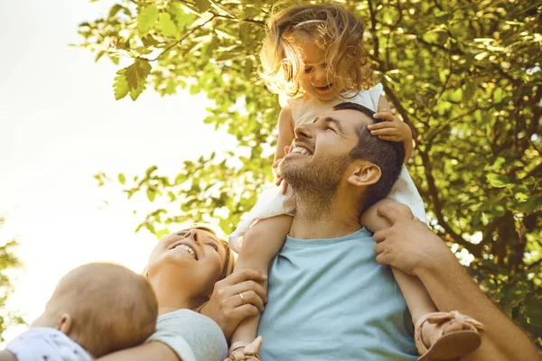 Happy parents with children in the park at sunset. — Stok fotoğraf