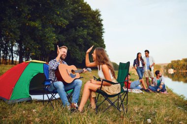 Sonbaharda doğada bir piknik bir gitar ile Arkadaşlar.