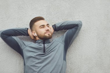 El ele tutuşan sakallı adam gri bir arka plan düşlüyor..