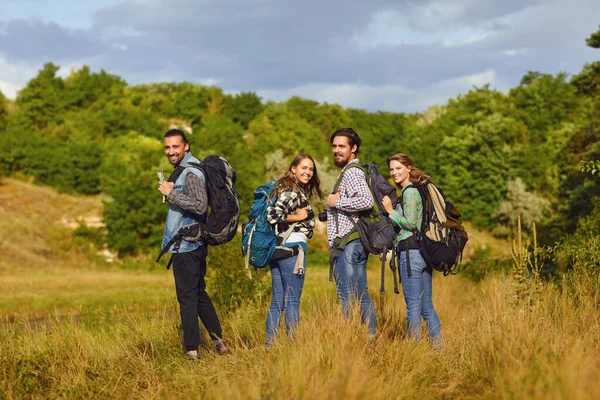 Skupina turistů s batohy se v přírodě krájí — Stock fotografie