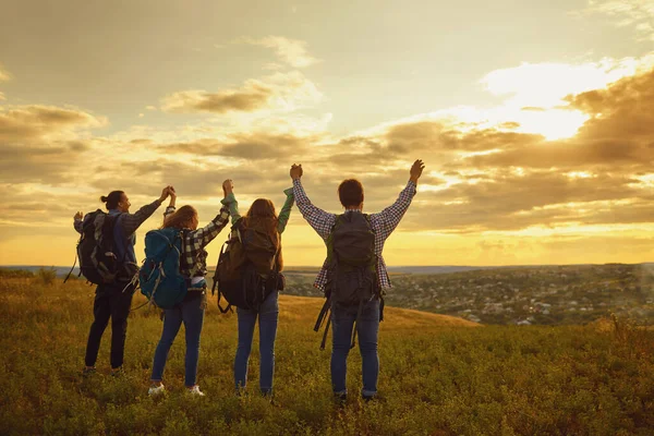 Gente feliz turistas al atardecer en la naturaleza . — Foto de Stock