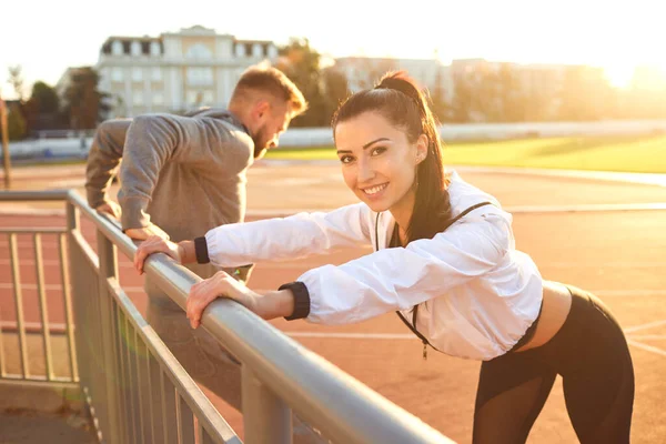 Spor giyimli çift stadyumda ısınma yapıyor — Stok fotoğraf