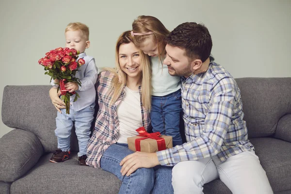 Happy funny family giving presents while sitting on sofa at home. — Zdjęcie stockowe