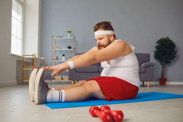 Funny red fat man doing exercises on the floor while standing at home. — 스톡 사진