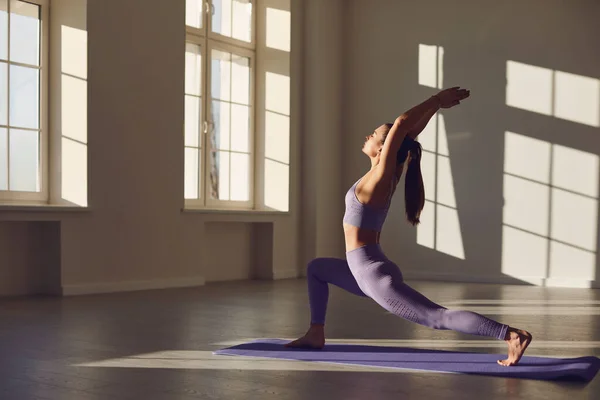 Chica posando en yoga posan en una habitación al amanecer en el sol . —  Fotos de Stock