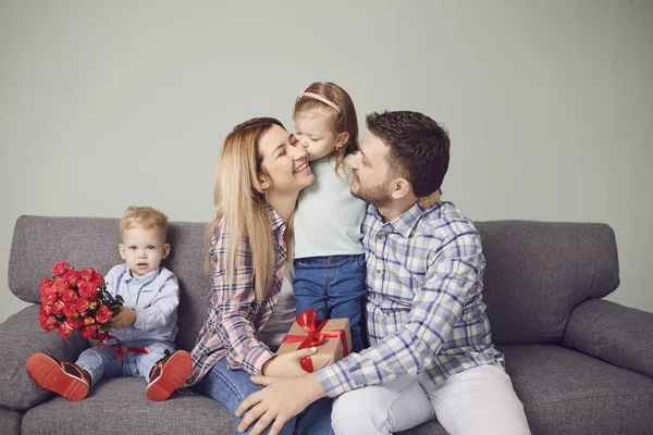 Happy funny family giving presents while sitting on sofa at home. — Stok fotoğraf