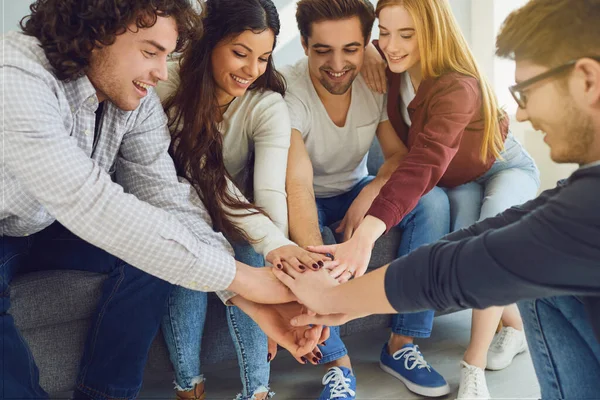 Des amis heureux levèrent joyeusement les mains dans une pièce avec une fenêtre . — Photo