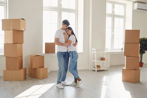 Happy couple cuddles standing in a new house. — Stockfoto
