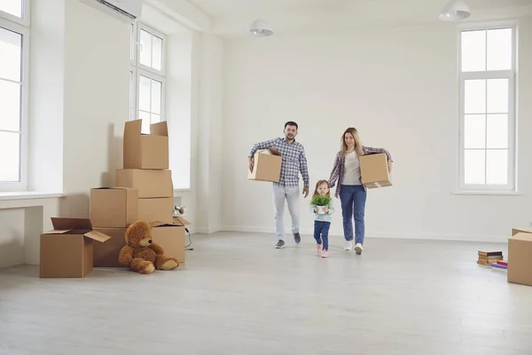 Glad familj med barn flyttar med lådor i ett nytt lägenhetshus. — Stockfoto