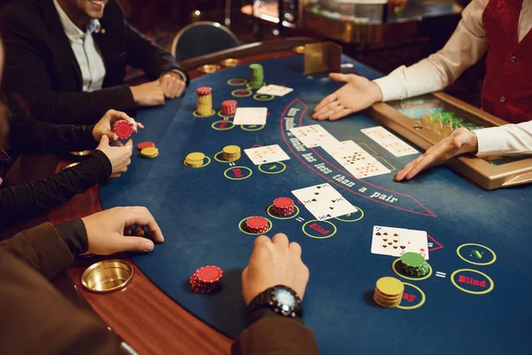 As pessoas jogam em uma mesa de poker em um cassino . — Fotografia de Stock
