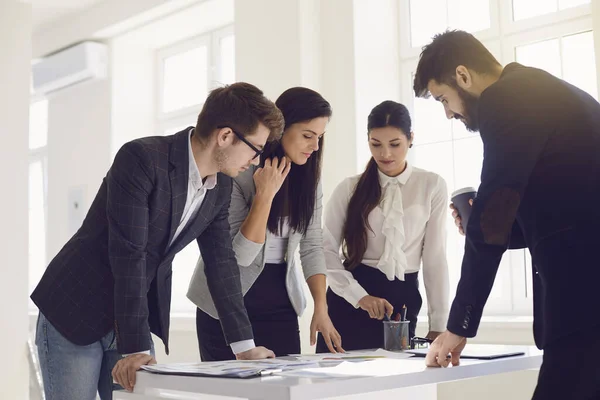 Equipo de empresarios en una reunión discutiendo un proyecto de startup en una mesa en una oficina con ventanas . —  Fotos de Stock