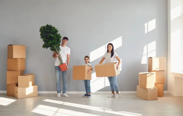 Glückliche Familie mit Kindern zieht mit Kisten in ein neues Mehrfamilienhaus. — Stockfoto
