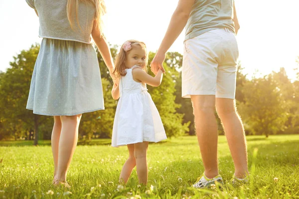 Glad familj går på gräset i sommarparken. Barnens skyddsdag. — Stockfoto