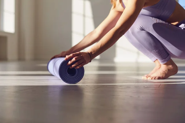 Fitness yoga workout vrouw. Een vrouw met een yoga mat in een witte kamer in een heldere kamer. — Stockfoto