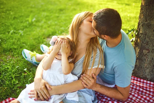 Gelukkige familie rust op het gras in het park. — Stockfoto