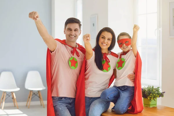 Happy family of superheroes laughing in a room indoors. — Stock Photo, Image