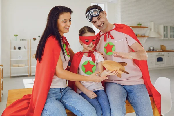 Família feliz de super-heróis em um quarto dentro de casa . — Fotografia de Stock