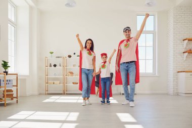 Süper kahraman kostümlü mutlu aile evde macera oynuyor..