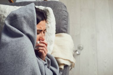 Karantina. Coronavirüs. Koronavirüs semptomları olan bir kadın evdeki kanepede karantinada yatıyor..