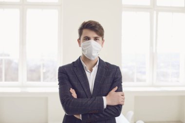 Virüs koronavirüs enfeksiyonu tehlikesi. Ofiste maskeli bir iş adamı var.
