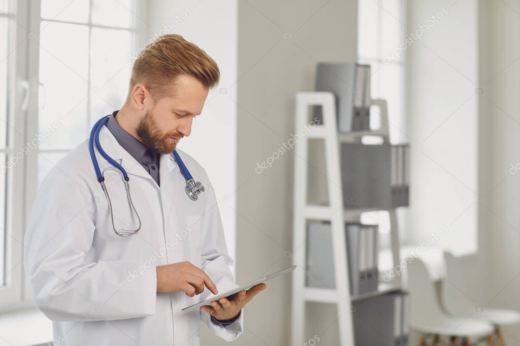 Male doctor pediatrician standing in the white office of the hospital.