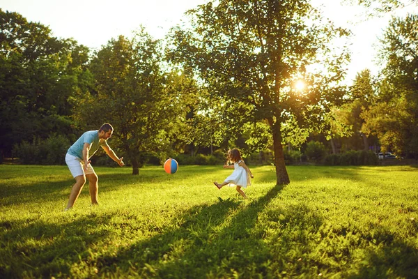 Fathers day. Father plays with his daughter in the summer park. — Stockfoto