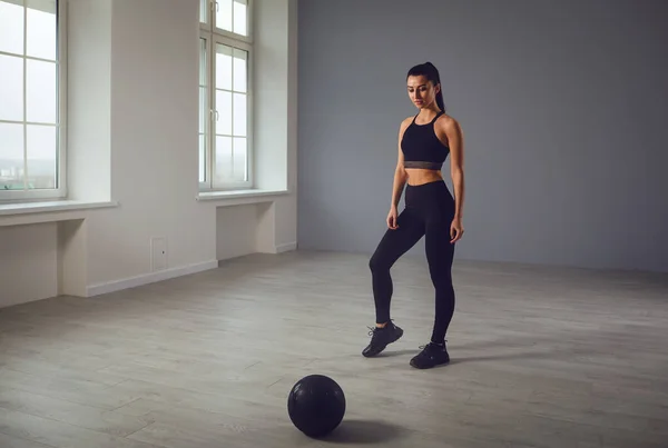 Kız sağlık topuyla spor yapmaya gidiyor. Bir spor kızı kapalı bir odada egzersiz yapar.. — Stok fotoğraf
