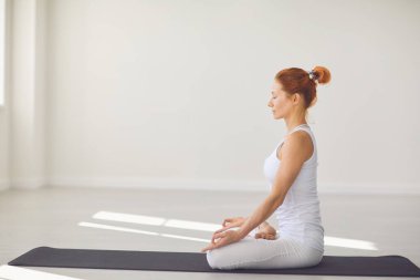Yogacı kız. Fitness kızı stüdyoda lotus pozisyonunda yoga yapıyor.
