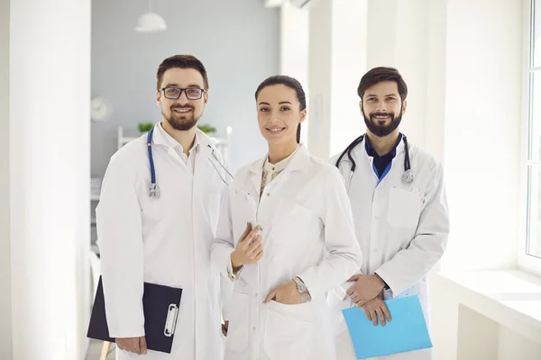 Um grupo de médicos bem sucedidos está sorrindo para a clínica . — Fotografia de Stock