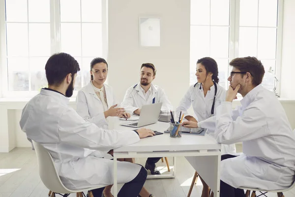 Gruppo di medici praticanti in una riunione discutere la diagnosi di un paziente in piedi in uno studio clinico. — Foto Stock
