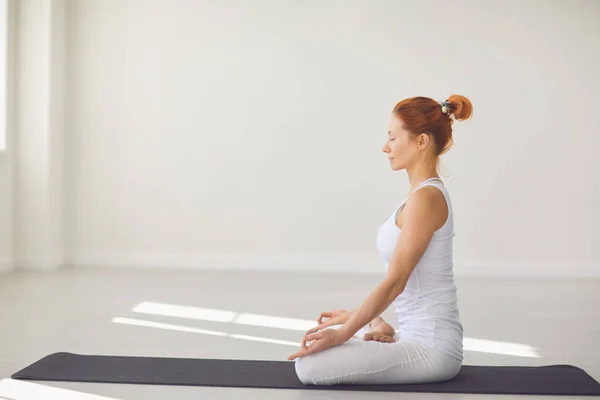 Chica del yoga. Chica de fitness está practicando yoga en una posición de loto sentado en un estudio — Foto de Stock