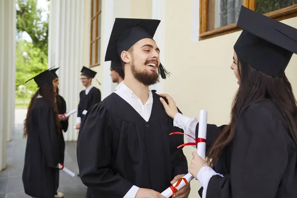 Női diplomások diplomával a kezükben átölelve — Stock Fotó