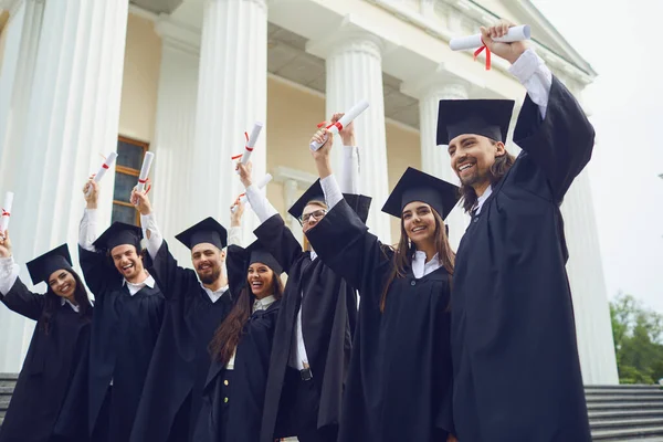 Eine Gruppe von Doktoranden hob die Hände mit Diplomen nach oben — Stockfoto